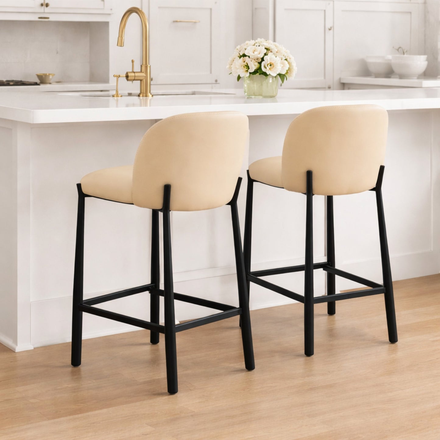 Ava counter stools styled at a modern white kitchen island with taupe upholstered seats and black metal legs