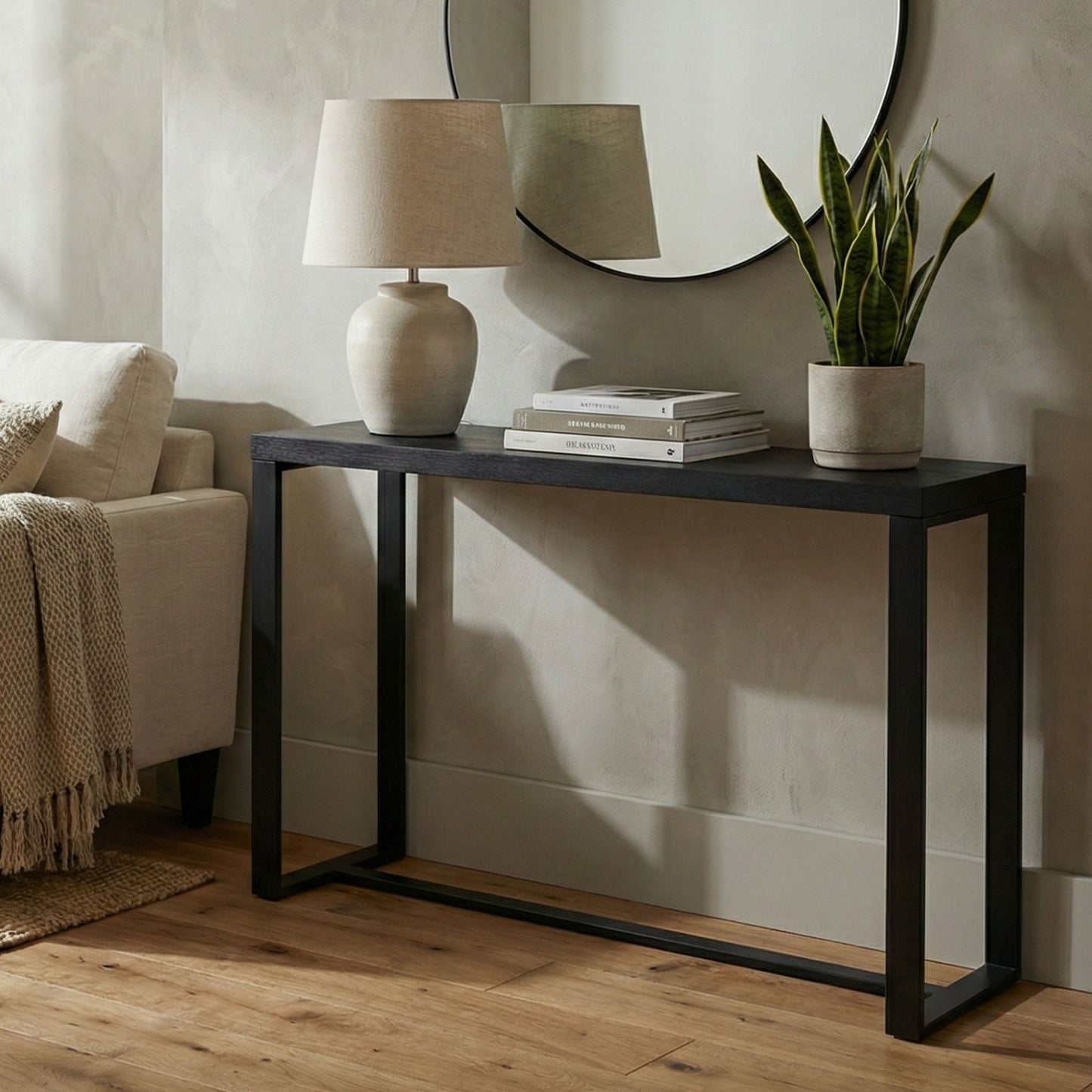 Black console table styled in a modern living room with lamp, books, and plant, perfect as an entryway or sofa table.