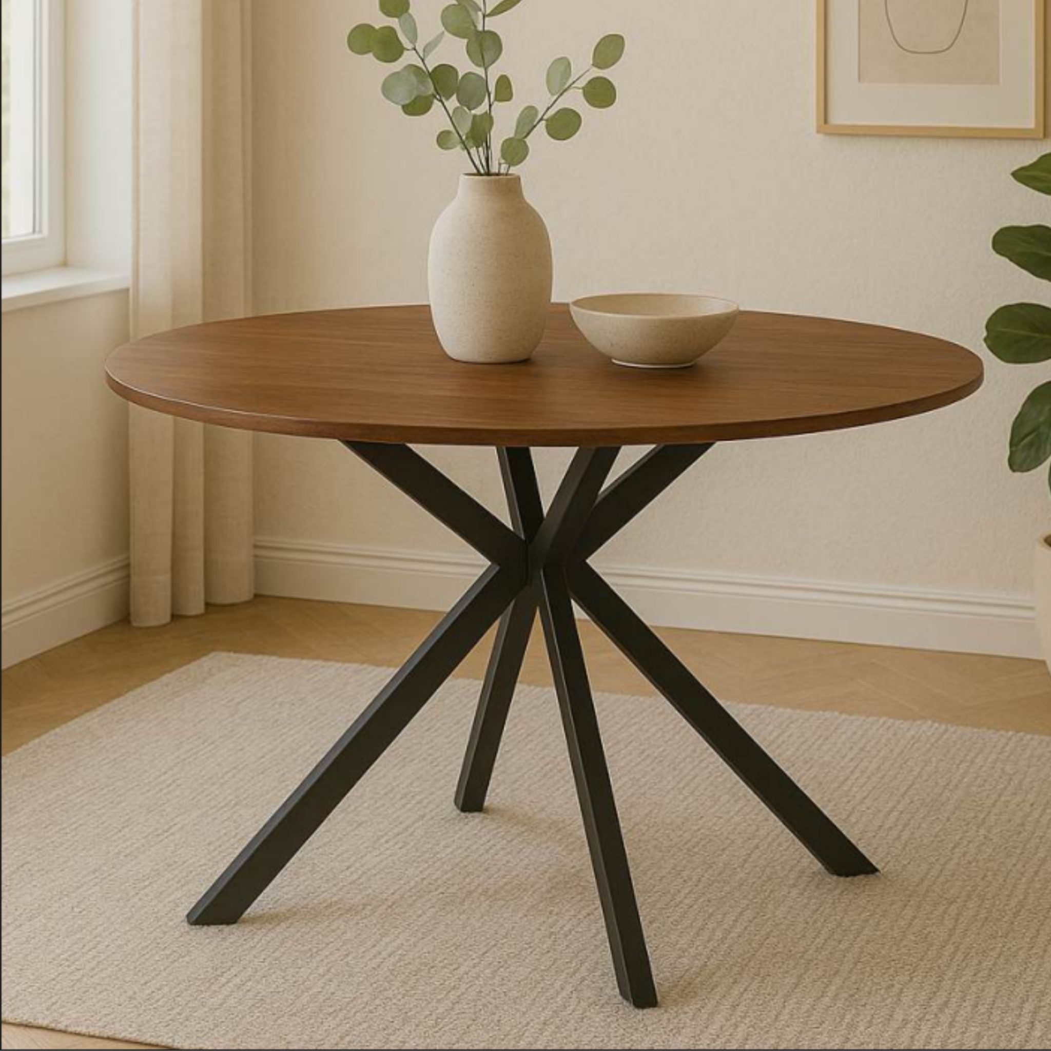 Ivanna walnut round dining table with black metal pedestal base styled in a bright modern dining space